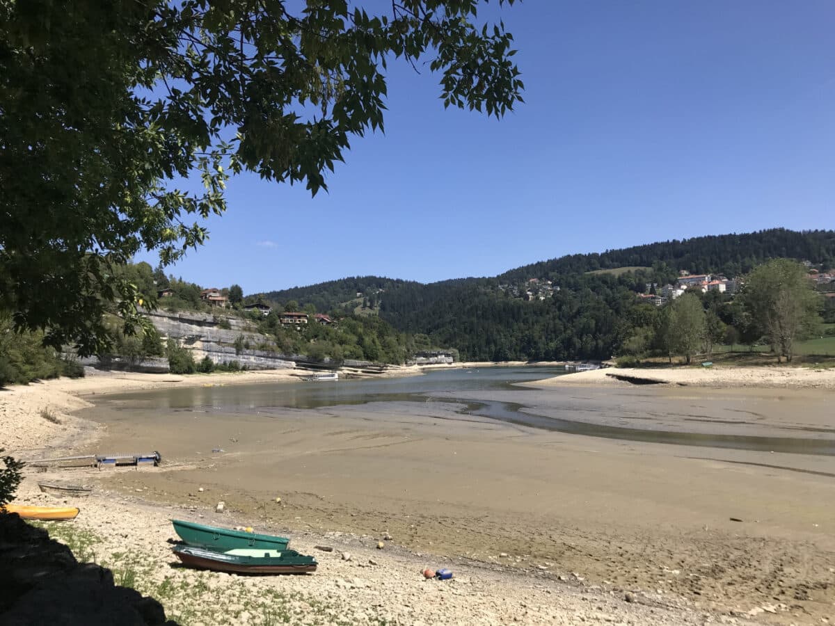 Cours d'eau asséché avec un village en fond